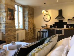a living room with a couch and a clock on the wall at Appartement centre-ville CHIC in Vannes