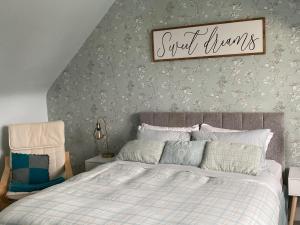 um quarto com uma cama e uma placa que lê doces sonhos em Alpine cottage em Crieff