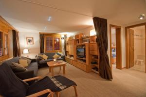 a living room with a couch and a tv at Haus Lizi, Apartment 8 in Zermatt