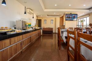 a restaurant with a buffet line with tables and chairs at Plaza Suite Hotel in Taubaté