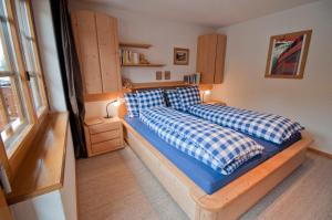 a bedroom with a bed with blue and white pillows at Haus Lizi, Apartment 8 in Zermatt