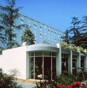a large white building with a large window at Hotel Terme in Monticelli Terme