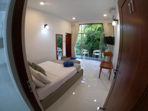 een slaapkamer met een bed en een groot raam bij Hill Country Villa in Kandy