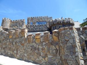 un mur en pierre avec une fenêtre au-dessus dans l'établissement Hotel Boutique Castillo del Mar, à El Quisco