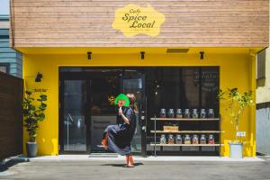 a woman standing in front of a store holding a frisbee at Ten to Ten Hostel in Sapporo