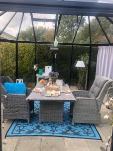 een tafel en stoelen in een prieel bij De Tuinkamer in Ter Apel