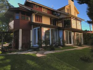 a large house with a lawn in front of it at Suites Refugio Do Vale in Gramado