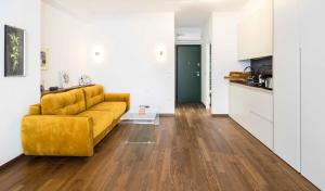 ein Wohnzimmer mit einem gelben Sofa und einer Küche in der Unterkunft Athens' Best Location- Unique Magnificent Studio in Athen