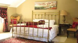 a bedroom with a bed and a painting on the wall at Bougain Villa Guesthouse in Winburg