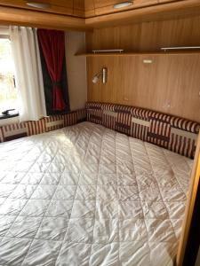ein großes Bett in einem Zimmer mit Stühlen und einem Fenster in der Unterkunft Husvagn i Hundfjället Sälen in Sälen