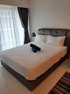 - un grand lit avec une tête de lit noire dans une chambre dans l'établissement Summer Suites Studios, à Kuala Lumpur