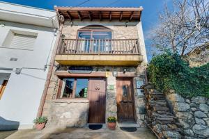 een huis met een houten deur en een balkon bij Restaurante & Casa Rural Boada in Villamiel