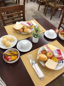 a table with plates of food on top of it at Hotel Vila Real Rex in Poços de Caldas