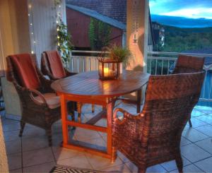 a table and chairs on a porch with a candle at Ferienwohnung am Obstgarten in Bad Bocklet