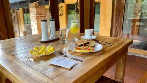 a wooden table with two plates of food and a glass of orange juice at Rancho San Antonio in Salento +27 photos