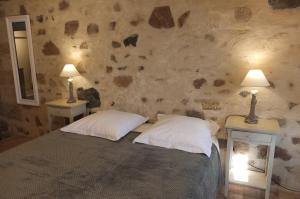 a bedroom with a bed with two lamps on two tables at La Pierre Folle Chambres d'Hôtes in Cluny