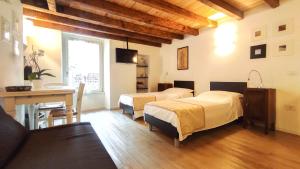 a room with two beds and a table and a desk at B&B ai Musei in Brescia