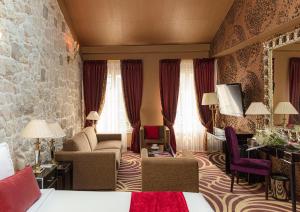 a hotel room with a bed and a living room at Hotel Du Beaumont in Paris