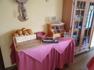 una mesa con mantel rosa y una cesta de pan en Pension Lindbichler, en Vorderstoder