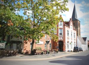 a large brick building with a steeple on a street at Hotel Landhaus Steinhoff in Rheinberg