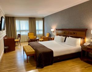 een hotelkamer met een bed en een tafel en stoelen bij Eurostars Araguaney in Santiago de Compostela