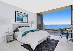 a bedroom with a large bed and a large window at Stylish Penthouse with Views & Jacuzzi in Gosford