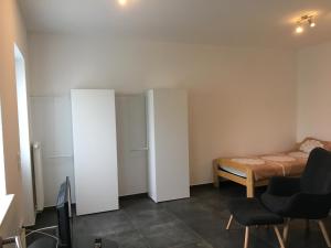 1 dormitorio con 1 cama, 1 cama y sillas en Monteurwohnung 1, en Ingelheim am Rhein