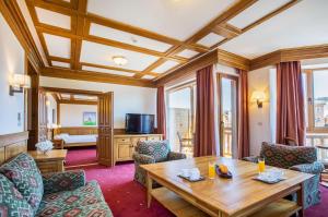 a living room with a wooden table and chairs at Pirin Golf Hotel & Spa in Bansko