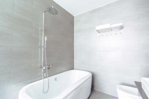 een witte badkamer met een bad en een douche bij Đà Lạt Mega Sky Hotel in Da Lat