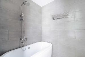 een badkamer met een wit bad en een douche bij Đà Lạt Mega Sky Hotel in Da Lat
