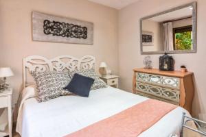 - une chambre avec un lit blanc et un miroir dans l'établissement Apartamentos Bellamar, à Cambrils