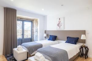 a bedroom with two beds and a window at Casa da Veiga in Aldeia