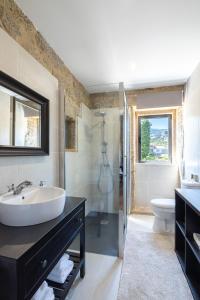 a bathroom with a sink and a shower and a toilet at Casa da Veiga in Aldeia