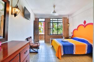 a bedroom with a bed and a desk and a chair at Hotel Villa del Mar Tradicional in Puerto Vallarta