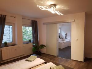 a bedroom with two beds and a bathroom with a sink at Pilgrims "Resi" charmante Unterkunft Sauerland in Meschede