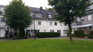 a large white house with trees in a yard at Pilgrims "Resi" charmante Unterkunft Sauerland in Meschede