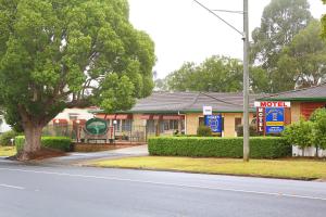 
a street scene with a house and a tree at Garden City Motor Inn in Toowoomba
