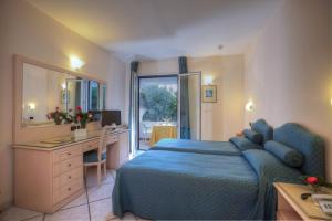 a bedroom with a blue bed and a desk and a computer at Le Querce Resort Sea Thermae & Spa in Ischia