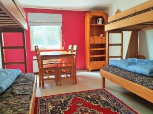 a bedroom with two bunk beds and a table and chairs at HOSTEL and VANDRARHEM LUPIN Naturcamping Lagom in Gräsmark