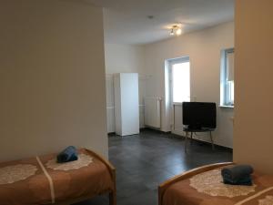 a room with two beds and a television in it at Monteurwohnung 2 in Ingelheim am Rhein