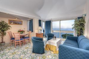a living room with a blue couch and chairs and a table at Le Querce Resort Sea Thermae & Spa in Ischia