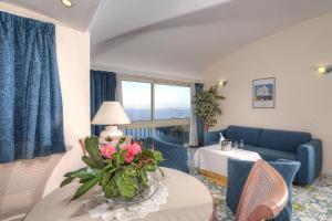 a living room with a couch and a table with flowers on it at Le Querce Resort Sea Thermae & Spa in Ischia