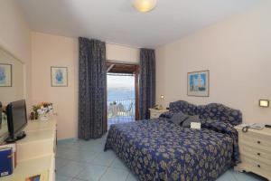 a bedroom with a bed and a television and a window at Le Querce Resort Sea Thermae & Spa in Ischia