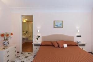 a bedroom with a bed and a bathroom with a sink at Le Querce Resort Sea Thermae & Spa in Ischia