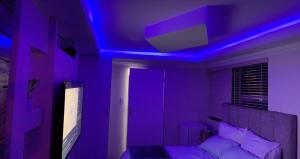a purple room with a bed and a blue ceiling at Made Guest House in Johannesburg