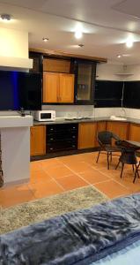 a large kitchen with a table and a microwave at Made Guest House in Johannesburg