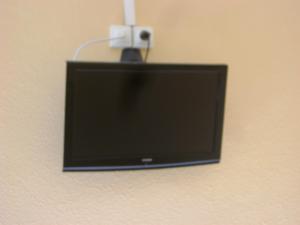 a flat screen tv hanging on a wall at Hôtel Restaurant La Casera in Clarac