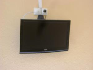 a flat screen tv hanging on a wall at Hôtel La Casera in Clarac
