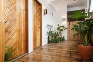 a hallway with a wooden door and potted plants at SANSE Boutique Hotel in El Nido