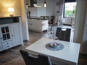 cocina y sala de estar con mesa blanca y sillas en Dorfidylle - Thüringer Wald Rennsteig, en Friedrichroda